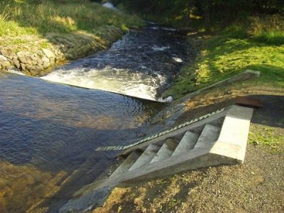 Vodočet u schodiště měrného objektu Šikmá vodočet vedle betonového schodiště u měrného objektu lesního toku